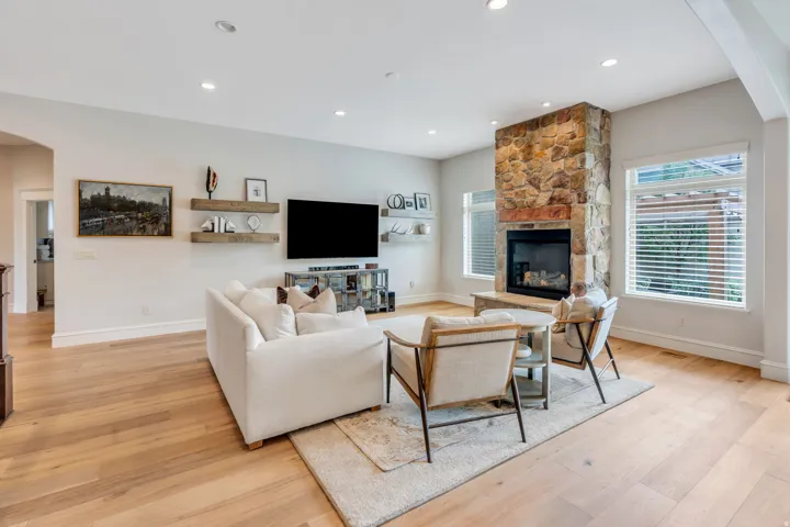 Great room with gas fireplace, lots of natural light and beautiful hard wood flooring.