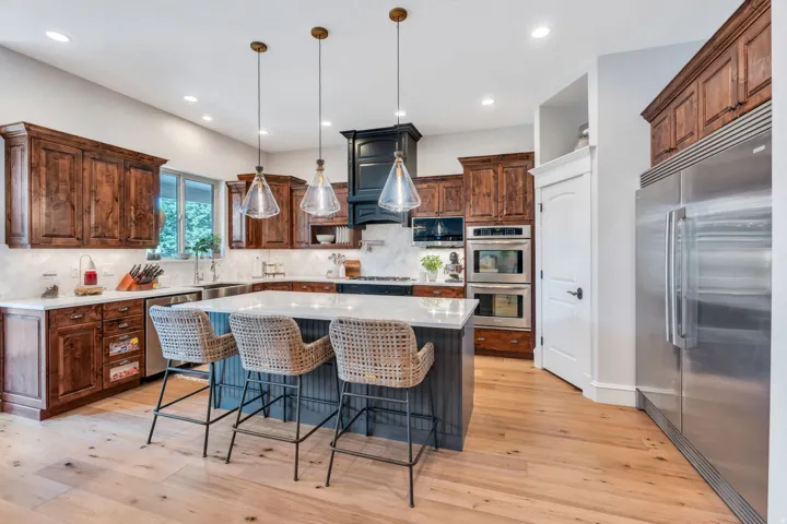 Well-appointed kitchen featuring custom appliances and large corner pantry.