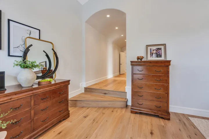 Spacious master bedroom with custom wood flooring.
