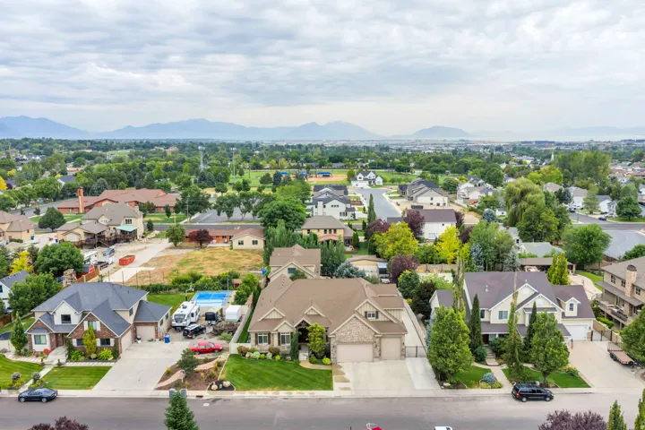 Residential neighborhood with mature trees and distant mountains.