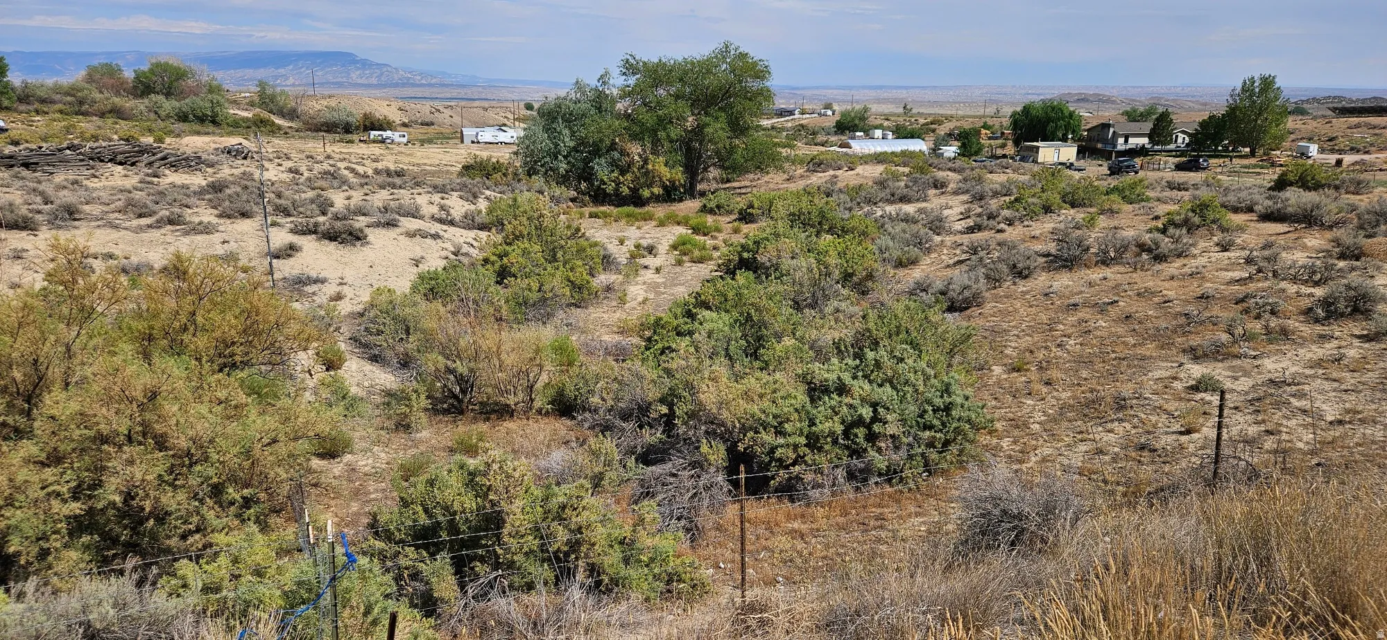 Expansive desert landscape with natural vegetation and distant structures