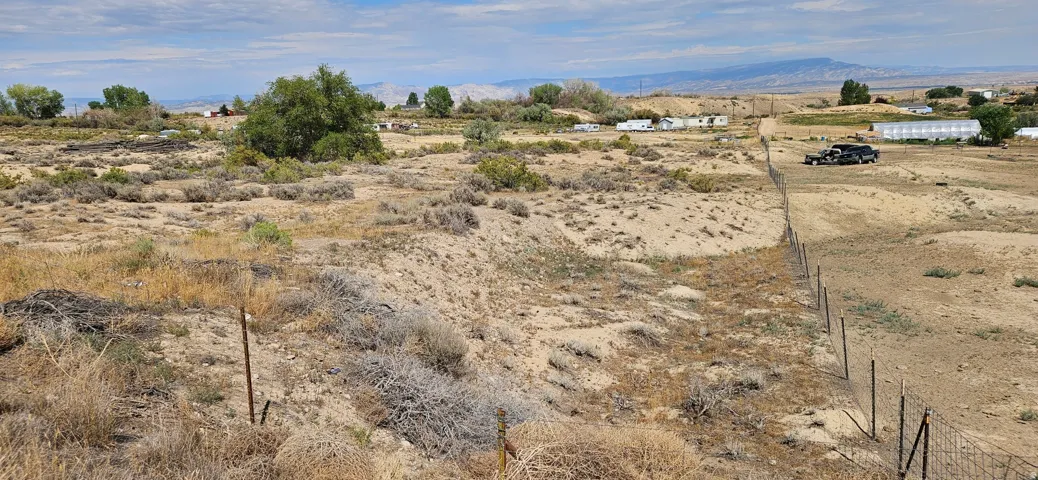 Expansive desert landscape featuring natural vegetation and distant mountain ranges