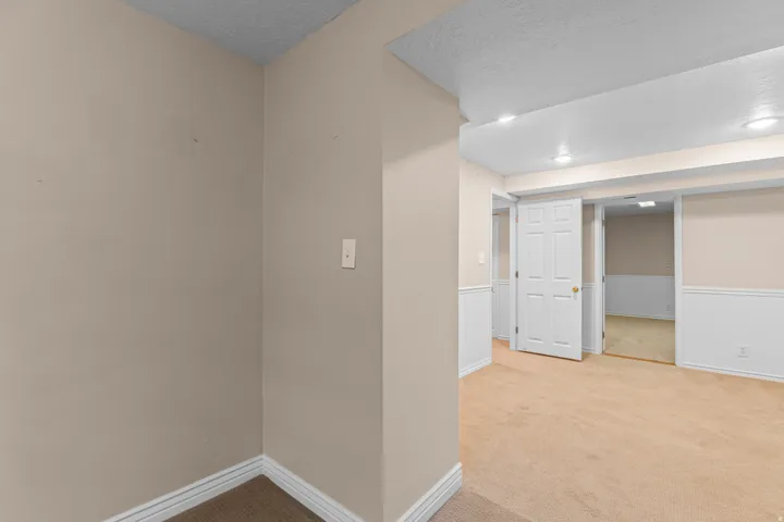 Recessed lighting, neutral-toned walls, white trim, paneled doors, and carpet flooring