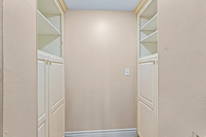 Built-in cabinetry with adjustable shelving, integrated door pulls, and a recessed baseboard