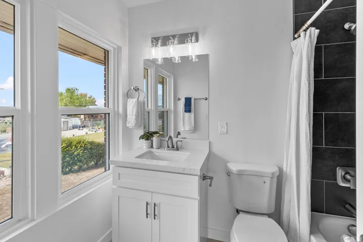 White vanity with a single basin sink, chrome faucet, and integrated countertop