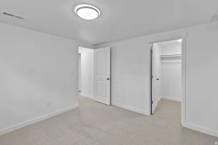 Plush carpeting, recessed lighting, built-in closet shelving, and a bright white ceiling