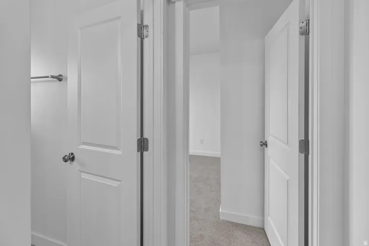 White interior doors with panel detailing, coordinating door hardware, and light gray wall paint