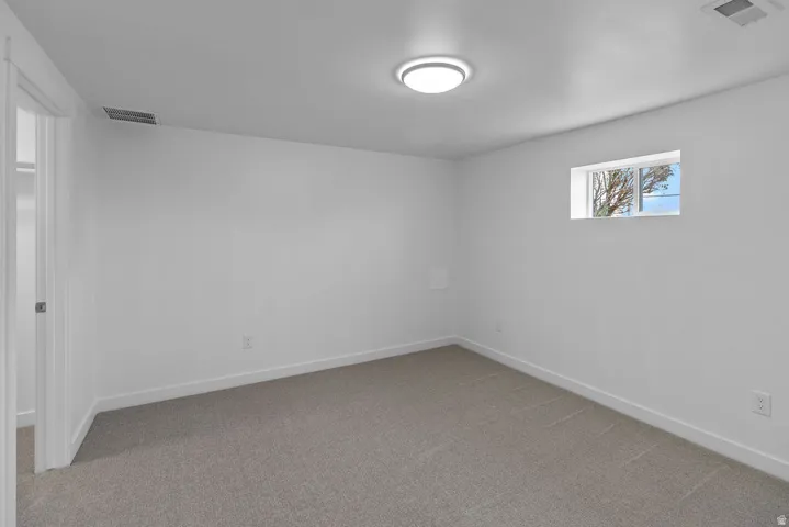 Wall-to-wall carpeting, fresh white walls, and a recessed window
