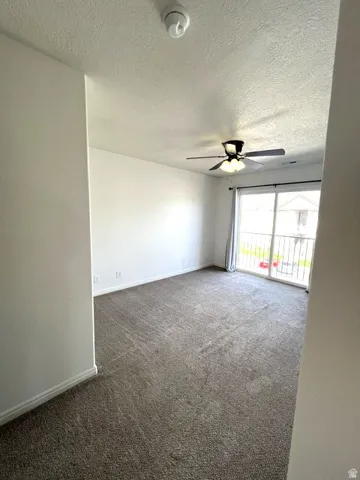 Wall-to-wall carpeting and a ceiling fan with integrated lighting