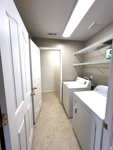 Laundry area featuring overhead fluorescent lighting and wire shelving