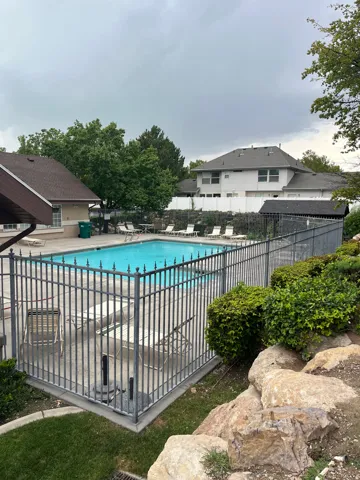 Fenced pool area with concrete decking