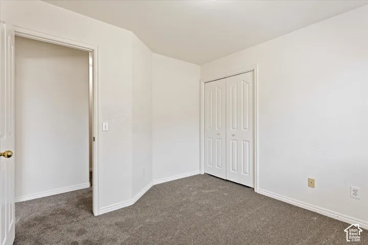 Neutral tone wall finish with textured carpet flooring