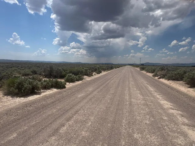 Expansive land parcel featuring a gravel road and natural desert vegetation