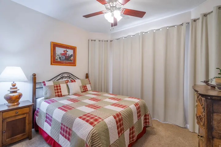 2nd Bedroom with a ceiling fan and light fixture and blackout drapes