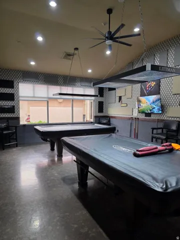 Recreational area featuring two billiards tables, recessed lighting, a modern ceiling fan, and textured wall coverings
