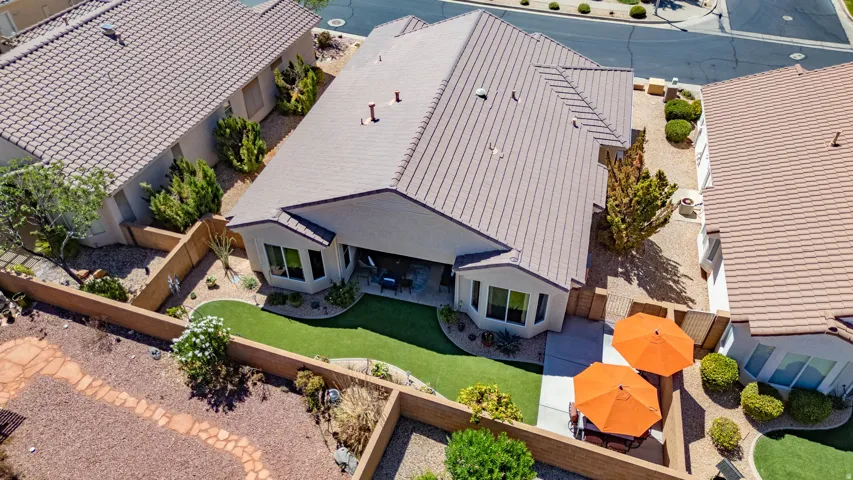 Tile roof, rear patio with artificial turf, enclosed backyard, and desert landscaping