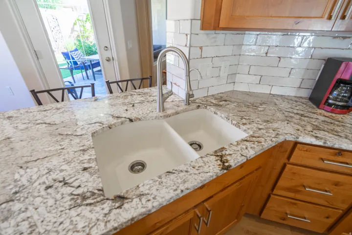 Composite Granite dual basin sink with a high-arch brushed nickel faucet, set within a patterned stone granite countertop