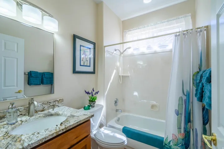 2nd bathroom with vanity with a granite countertop, undermount sink, and wood-finish cabinetry