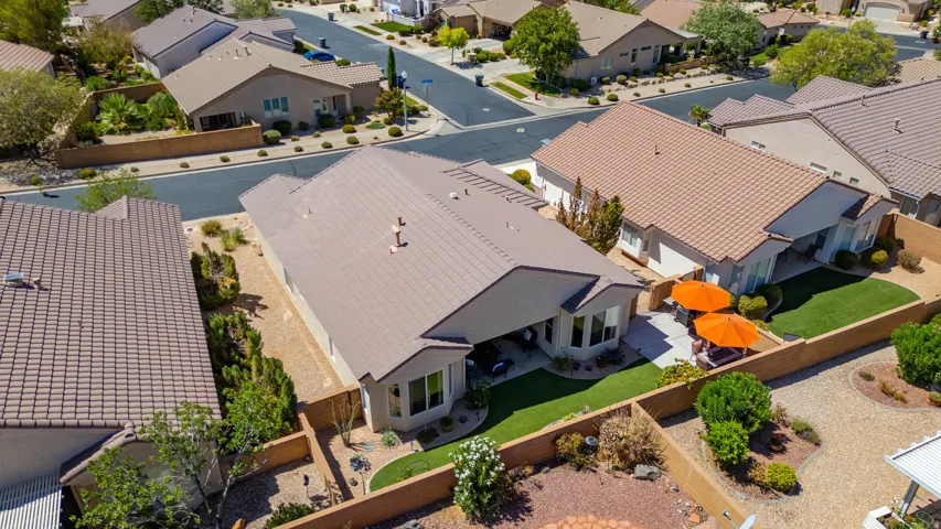 Expansive backyard featuring a manicured lawn, paved patio, and mature landscaping