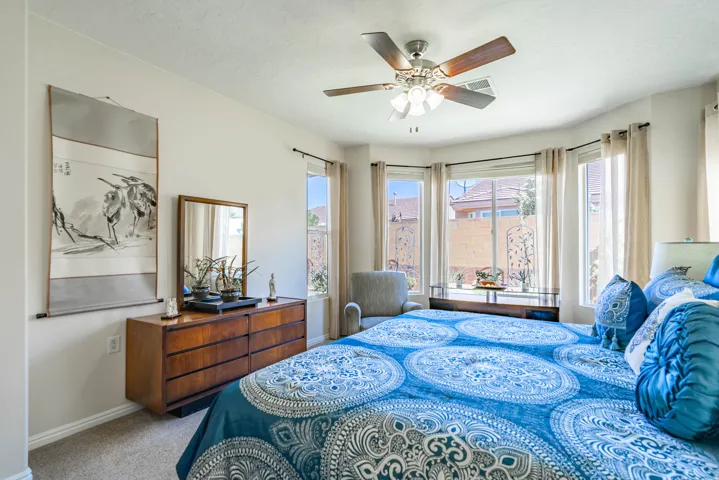 Recessed lighting, ceiling fan, carpet flooring, and bay windows in primary bedroom