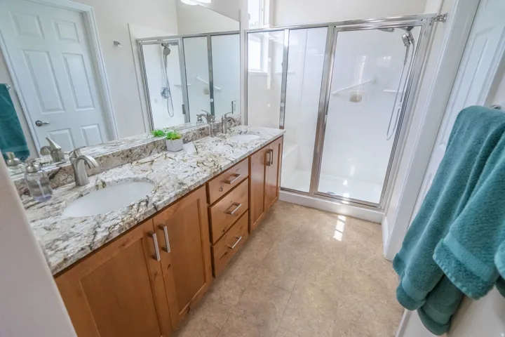 Primary Bathroom with dual vanity with granite countertop, undermount sinks, and brushed nickel fixtures