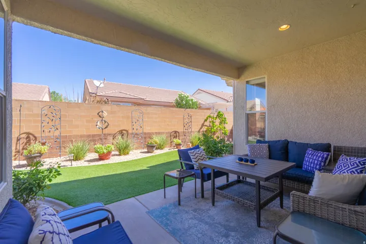 Covered patio area with recessed lighting, concrete flooring, and a window