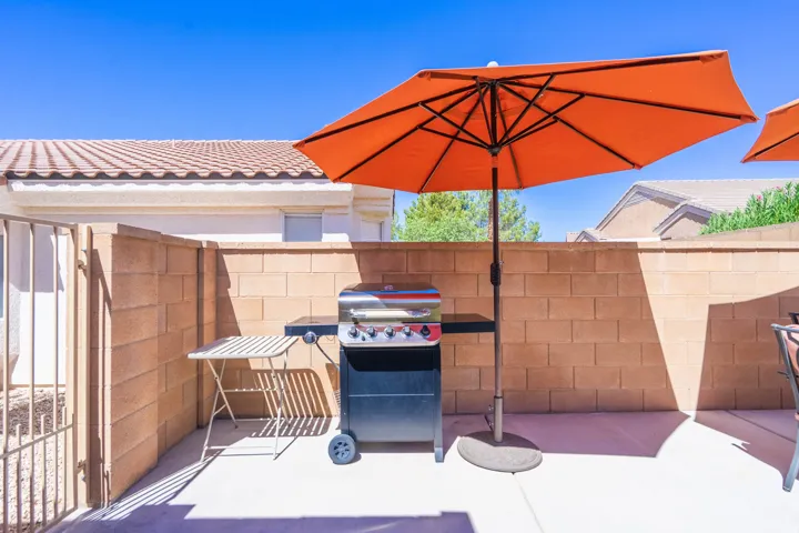 Paved outdoor area with block wall perimeter, featuring a metal gate