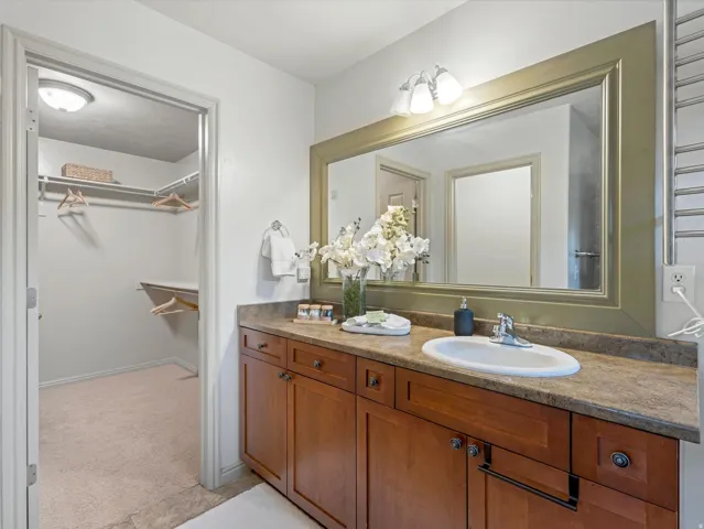Bathroom vanity with wood-finish cabinetry, an integrated sink, and a framed mirror
