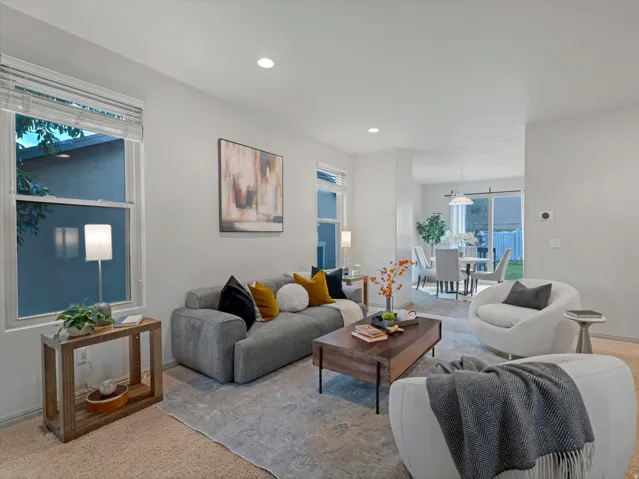 Recessed lighting, light-toned walls, and wood-finish flooring provide a bright living space