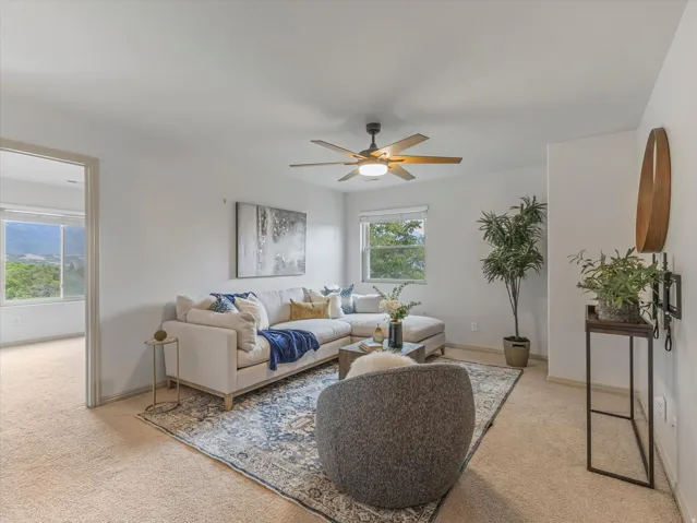 Neutral-toned carpeting throughout, with a ceiling fan featuring a central light fixture