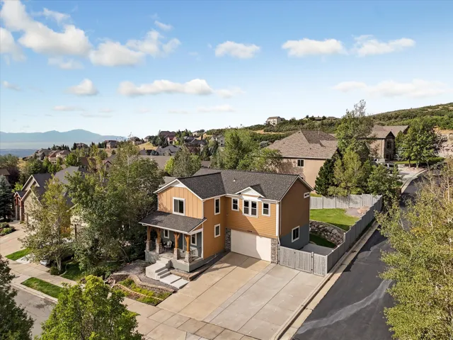 Two-story residence with a covered porch, attached garage, and a fenced yard