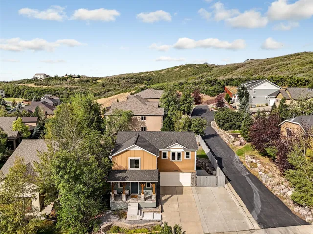 Two-story residence featuring a covered front porch, attached garage, and paved driveway