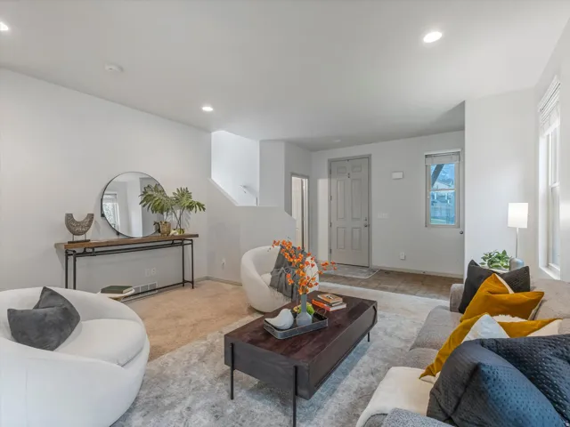 Recessed lighting throughout, light neutral wall colors, carpeted flooring, window with blinds, and white trim molding
