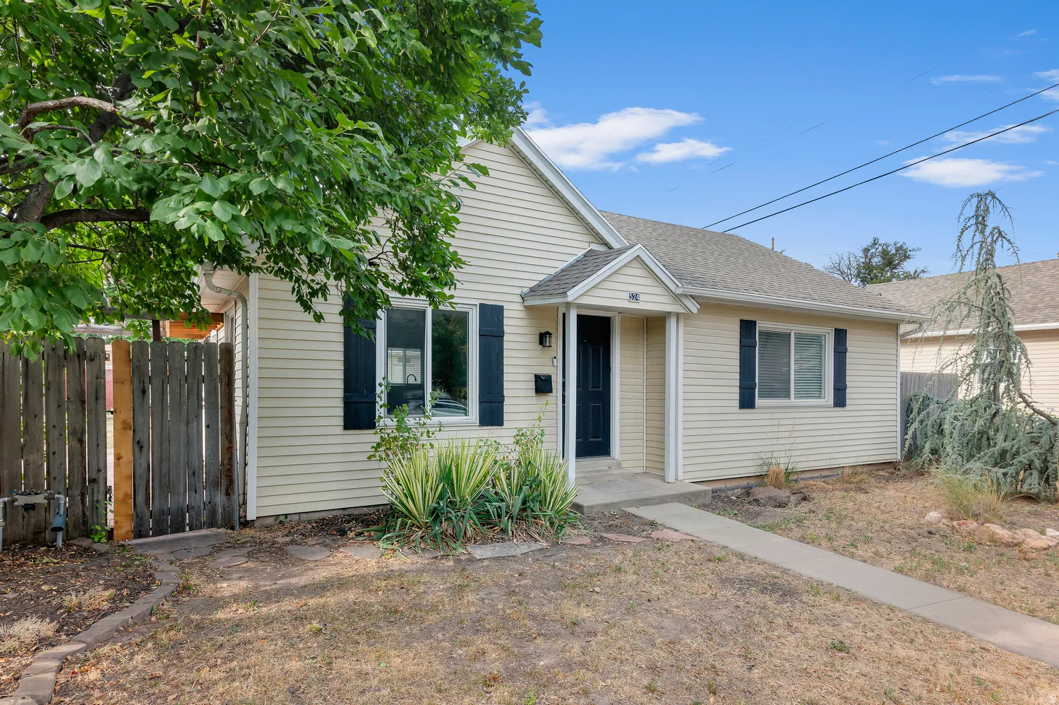 Light-colored siding exterior, dark entry door, and dark window shutters