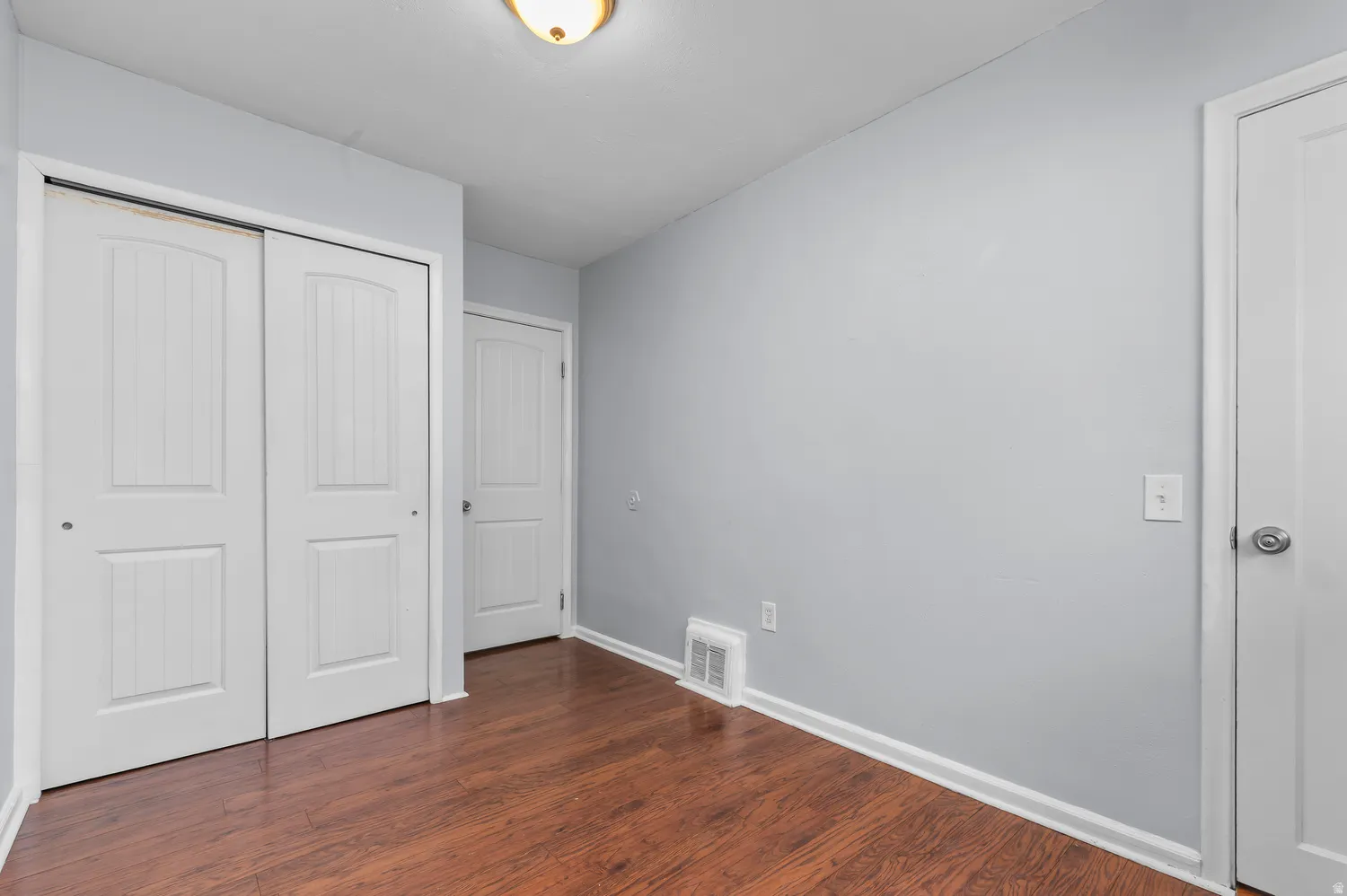 Wood-finish flooring, white trim, and light gray walls
