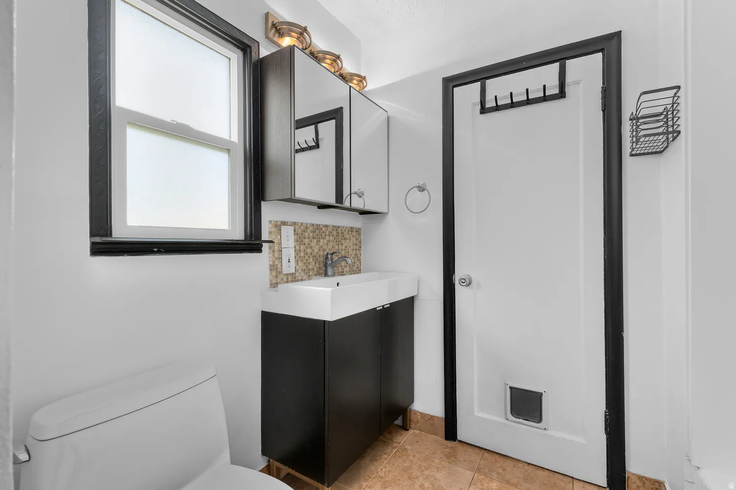 Modern vanity with rectangular basin sink, mosaic tile backsplash, and coordinating mirrored medicine cabinets