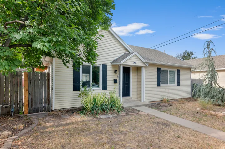Light-colored siding exterior, dark entry door, and dark window shutters