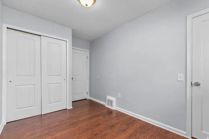 Wood-finish flooring, white trim, and light gray walls