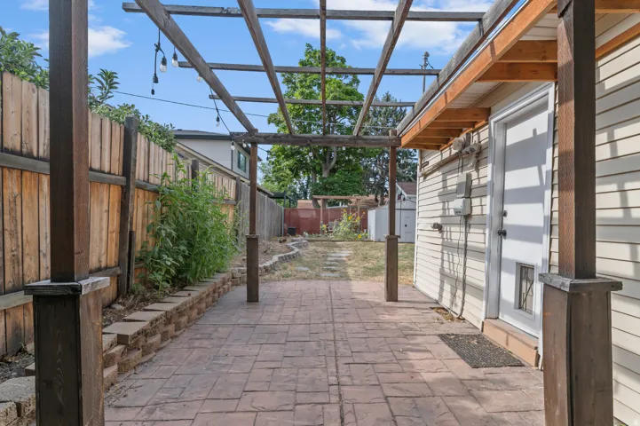 Patio featuring stamped concrete, wood pergola, and string lighting