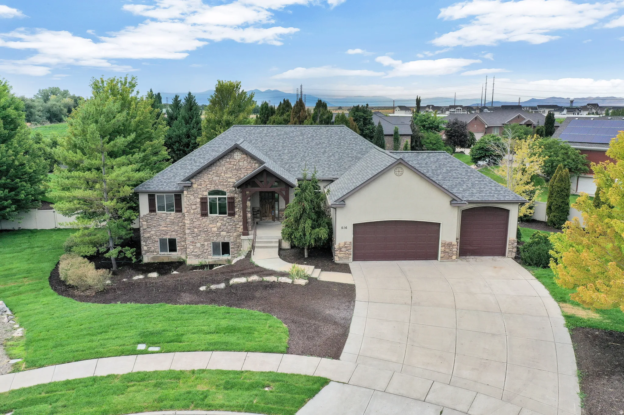 Stone and stucco exterior with a gray shingle roof