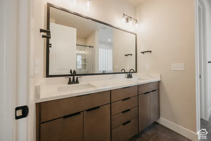 Dual vanity with undermount sinks, stone-finish countertop, and wood-finish cabinetry