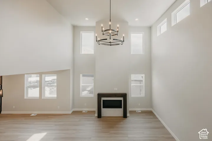 Vaulted ceilings, wood-finish flooring, and a modern fireplace with a dark wood mantel and light tile surround