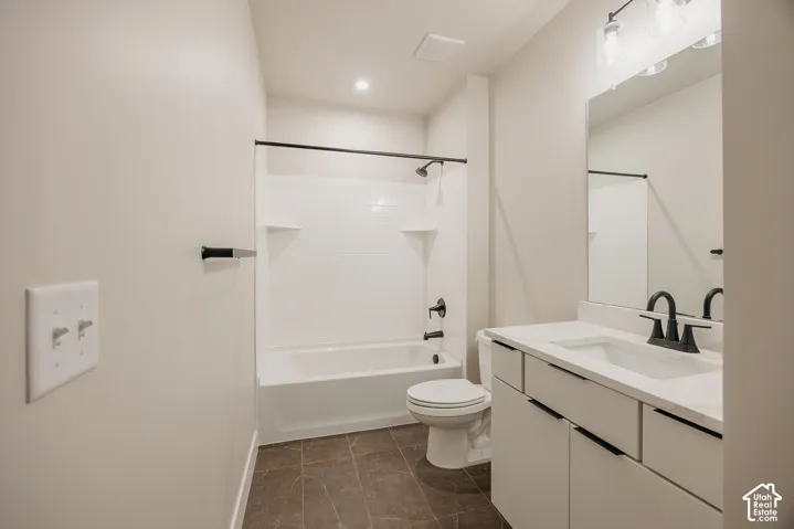 Bathroom featuring a white vanity with integrated sink, modern black fixtures, subway tile bath surround, and recessed lighting