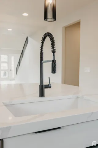 Integrated single basin sink with a black pull-down spring faucet, set within a light-toned countertop