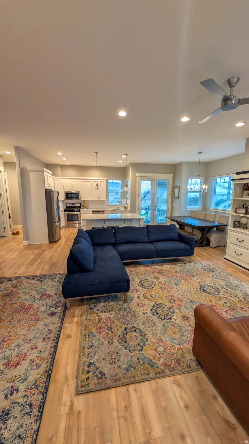 Open-concept living space featuring wood-finish flooring, recessed lighting, and a ceiling fan