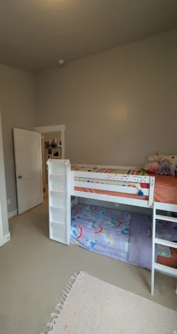 Carpeted room with a white interior door and neutral-toned walls