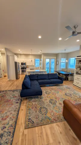 Open-concept living space featuring wood-finish flooring, recessed lighting, and a ceiling fan