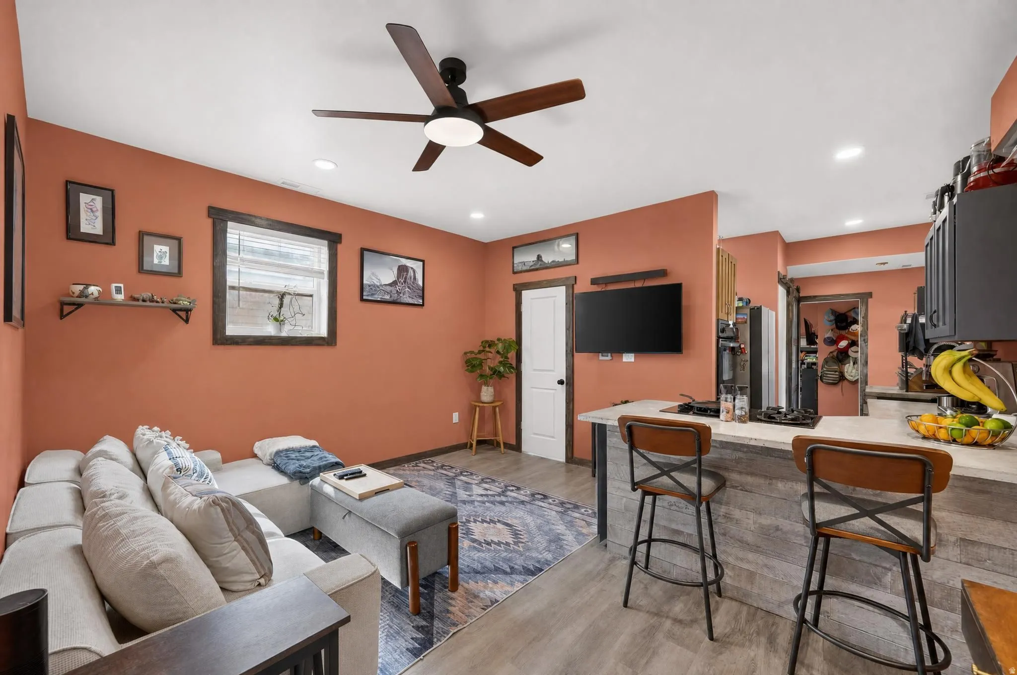 Open-concept living space with wood-finish flooring, recessed lighting, and a ceiling fan