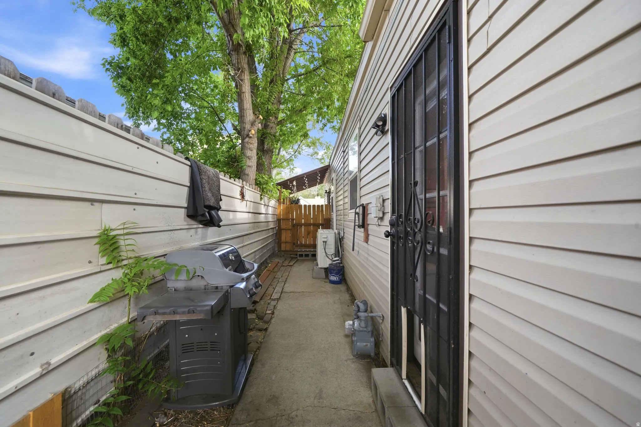 Exterior with horizontal siding, a security door, and a privacy fence