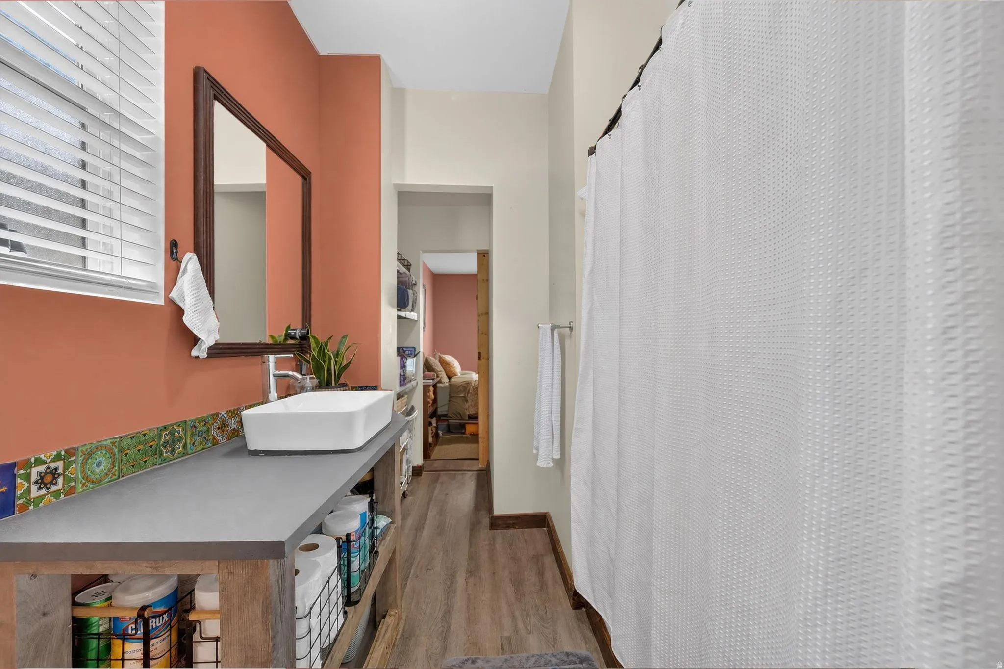 Vanity with a rectangular vessel sink, wall-mounted faucet, and colorful tile backsplash